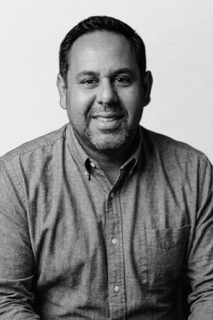 Dan Cortez of PoolMax discussing 3D pool design plans with a homeowner in their backyard.